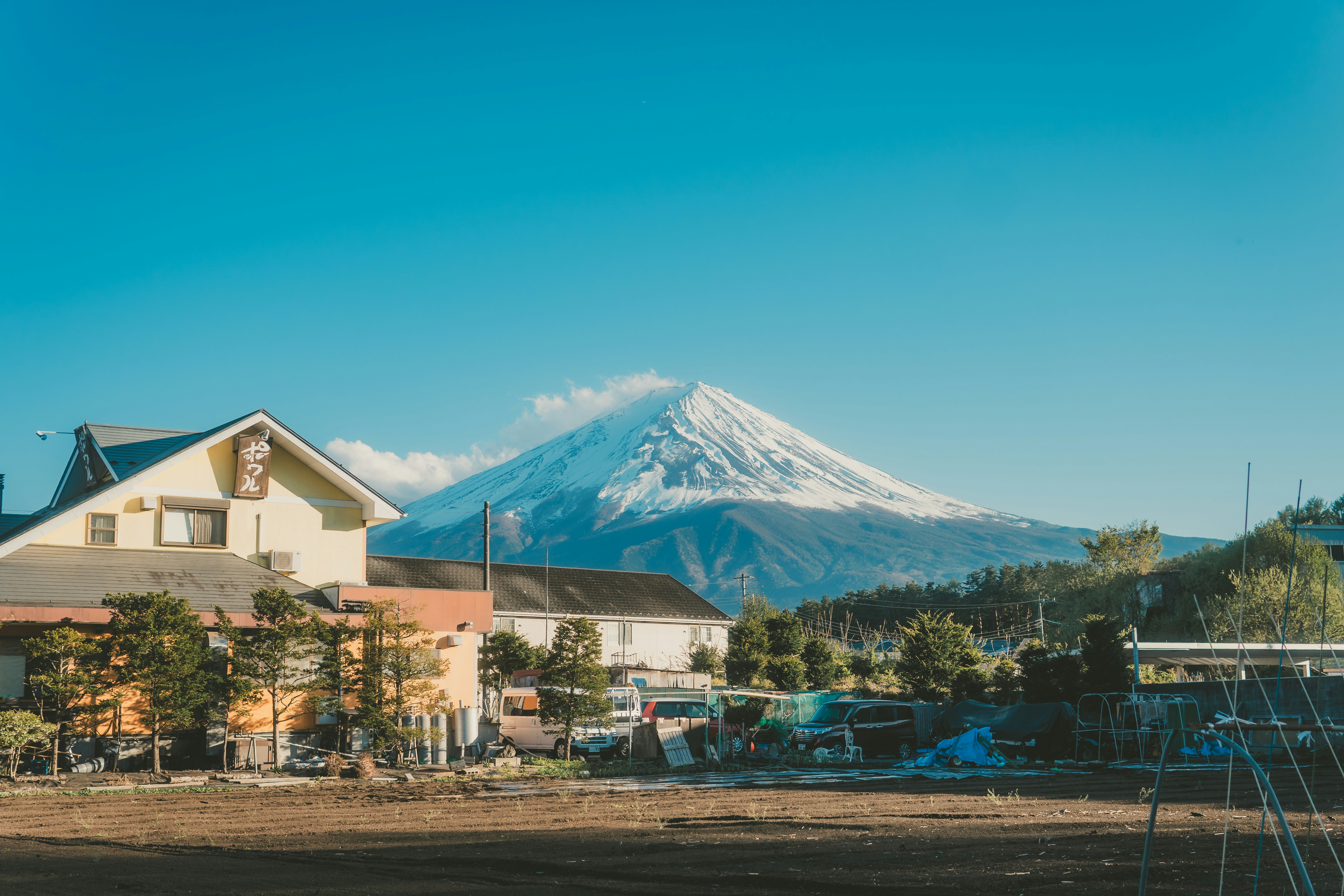 Everyday buildings and fields below a snowy mountain